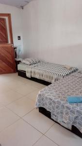 2 Betten nebeneinander in einem Zimmer in der Unterkunft aconchego in Pipa