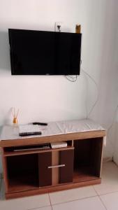 TV de pantalla plana sobre una mesa de madera en aconchego, en Pipa
