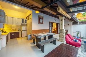 De Gani في سمينياك: مطبخ كبير مع طاولة خشبية وكراسي حمراء