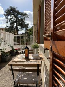 uma mesa com uma garrafa de vinho na varanda em Open the Classic Wooden Shutters at a Cozy City Nest em Florença