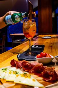 a person pours a glass of wine on a table with food at Hotel Ransol in El Tarter