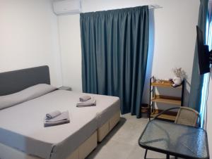 sypialnia z łóżkiem, krzesłem i oknem w obiekcie BlueSuite w Ajia Napa