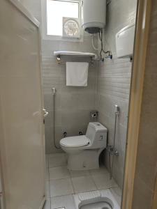 a small bathroom with a toilet and a window at فندق جارة الغيم للاجنحة الفندقية in Fayfāʼ