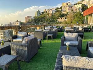 une rangée de chaises et de tables en osier sur un toit dans l'établissement فندق جارة الغيم للاجنحة الفندقية, à Fayfāʼ