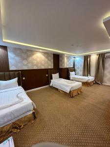 a hotel room with two beds in the middle at فندق جارة الغيم للاجنحة الفندقية in Fayfāʼ