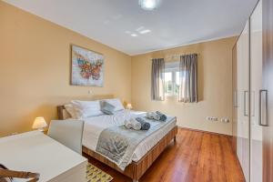 Schlafzimmer mit einem Bett und einem Fenster in der Unterkunft Coastal Paradise Villa with Pool - Happy Rentals in Sveti Filip i Jakov