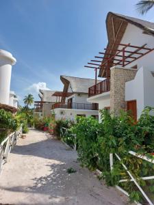 a building with a pathway next to a lighthouse at Room witch pool in garden 1 minutes from Ocean in Pingwe