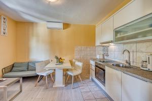 eine Küche mit einem Tisch, Stühlen und einem Sofa in der Unterkunft Coastal Paradise Villa with Pool - Happy Rentals in Sveti Filip i Jakov