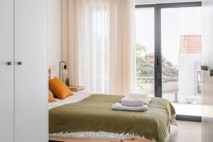 Beach, Ocean view & Bright House Ericeira في إيريسييرا: غرفة نوم بسرير ونافذة كبيرة
