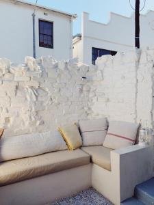 a couch in front of a stone wall at Cottage On Windsor in Cape Town