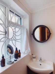 a bathroom with a sink and a mirror on a window at Cottage On Windsor in Cape Town