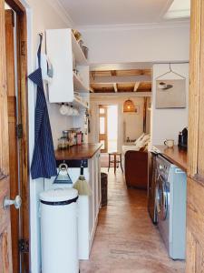 a kitchen and living room with a washer and dryer at Cottage On Windsor in Cape Town