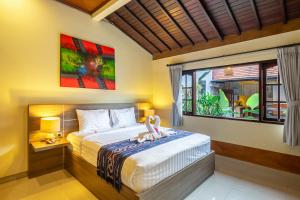 a bedroom with a bed and a large window at De Gani in Seminyak