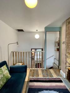 uma sala de estar com um sofá azul e uma escada em The Wabi Sabi House 