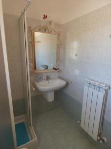 ein kleines Bad mit einem Waschbecken und einem Spiegel in der Unterkunft Appartamento Sirena in Tortoreto Lido