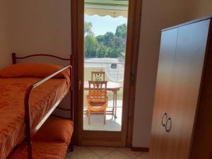 ein Schlafzimmer mit einem Balkon mit einem Tisch und einem Stuhl in der Unterkunft Appartamento Sirena in Tortoreto Lido