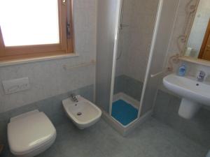 ein Bad mit einer Dusche, einem WC und einem Waschbecken in der Unterkunft Appartamento Sirena in Tortoreto Lido