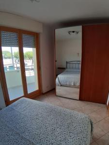 ein Schlafzimmer mit einem Bett und einem großen Spiegel in der Unterkunft Appartamento Sirena in Tortoreto Lido