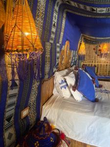 Tente et Restaurant ElBey في دوز: غرفة نوم مع سرير والجدران الزرقاء