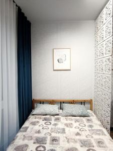 um quarto com uma cama e uma fotografia na parede em AlfaHome Lodz em Lódź