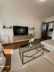 a living room with a coffee table and a tv at Appartement Cosy & Connecté à 15 min de Paris in Soisy-sous-Montmorency