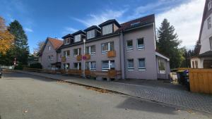 un gran edificio blanco al lado de una calle en Ferienwohnung Berglodge 11 Hahnenklee Bockswiese, en Goslar