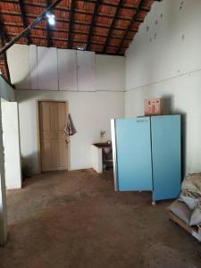 une pièce vide avec un réfrigérateur bleu dans l'établissement sitio rústico caconde, à Caconde