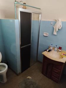 uma casa de banho com um chuveiro, um lavatório e um WC. em sitio rústico caconde em Caconde