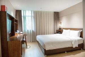 um quarto de hotel com uma cama e uma televisão em 客村喆啡酒店（广州国际会议展览中心店） em Guangzhou