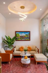 a living room with a couch and a chandelier at Golden Sun Hotel Hoi An in Hoi An