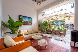 a living room with a couch and a table at Golden Sun Hotel Hoi An in Hoi An