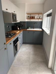 een kleine keuken met witte kasten en een wastafel bij Cosy Harrogate Haven in Harrogate