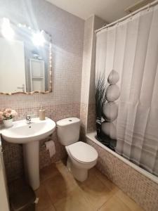a bathroom with a toilet and a sink and a mirror at Antigua Bay- Casa Margarita in Costa de Antigua