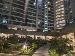 a walkway in front of a tall building at night at Regalia Suites Kuala Lumpur KLCC in Kuala Lumpur