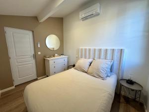 1 dormitorio con cama blanca y espejo en Maison Première ligne Tocade1, en Andernos-les-Bains