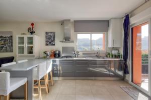 a kitchen with stainless steel appliances and a large window at Casa Azevedo in Vila Nova de Famalicão