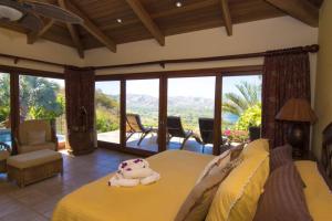 a bedroom with a yellow bed with a view at Casa Buena Vista in Coco