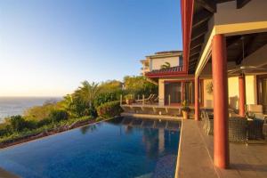 a house with a swimming pool next to the ocean at Casa Buena Vista in Coco