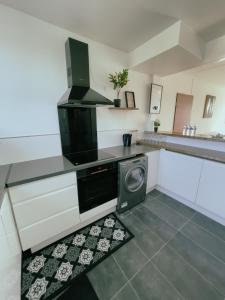 uma pequena cozinha com uma máquina de lavar roupa em Appartement Cosy & Connecté à 15 min de Paris em Soisy-sous-Montmorency