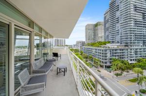 uma varanda com cadeiras e vista para a cidade em Spacious 3-Bedroom Midtown Condo em Miami