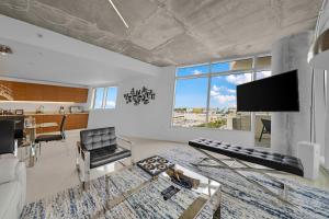 a living room with a tv and a dining room at Spacious 3-Bedroom Midtown Condo in Miami