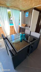 a glass table and chairs in a living room at TI KAZ PIROGUE in L'Étang-Salé les Bains