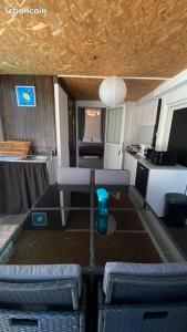 une chambre avec une table et deux chaises ainsi qu'une cuisine dans l'établissement TI KAZ PIROGUE, à Étang-Salé les Bains