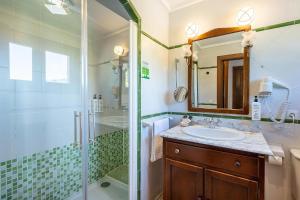 a bathroom with a shower and a sink and a mirror at Hotel Alahuar in Benimaurell