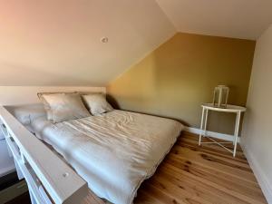 Bett in einem kleinen Zimmer mit Tisch in der Unterkunft Maison première ligne Tocade2 in Andernos-les-Bains