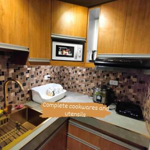 a kitchen with a sink and a microwave at Four Angels' 2 Bedroom in Manila
