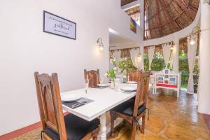 una sala da pranzo con tavolo e sedie bianchi di Minimi Couzy villa casaurina a Malindi