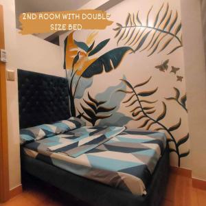 Schlafzimmer mit einem Bett mit Wandgemälde in der Unterkunft Four Angels' 2 Bedroom in Manila