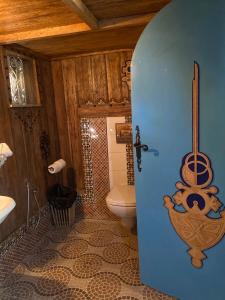 a bathroom with a sink and a toilet with a painting of a chicken at Tente et Restaurant ElBey in Douz