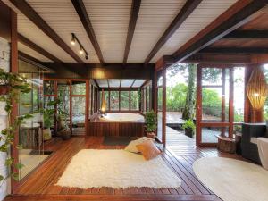 una grande camera con vasca da bagno e una camera con pavimenti in legno di Espaço Verde Novo Chalés a Teresópolis